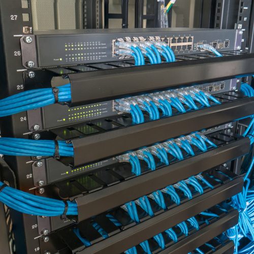 Network switch and ethernet cables in rack cabinet